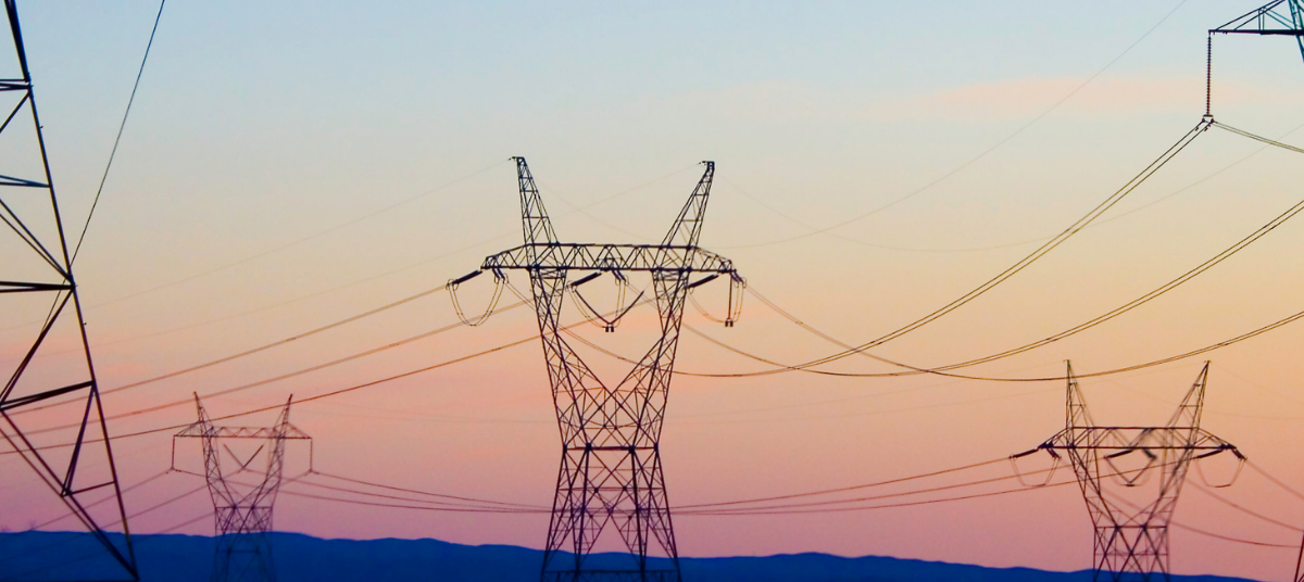 Electricity pylons at sunset distributing energy across the UK from renewable sources