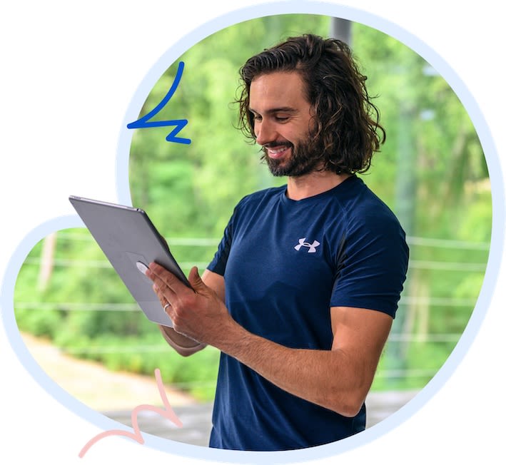 Joe Wicks reviewing a plan on his tablet