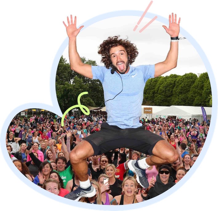 Joe Wicks jumping enthusiastically in front of a crowd
