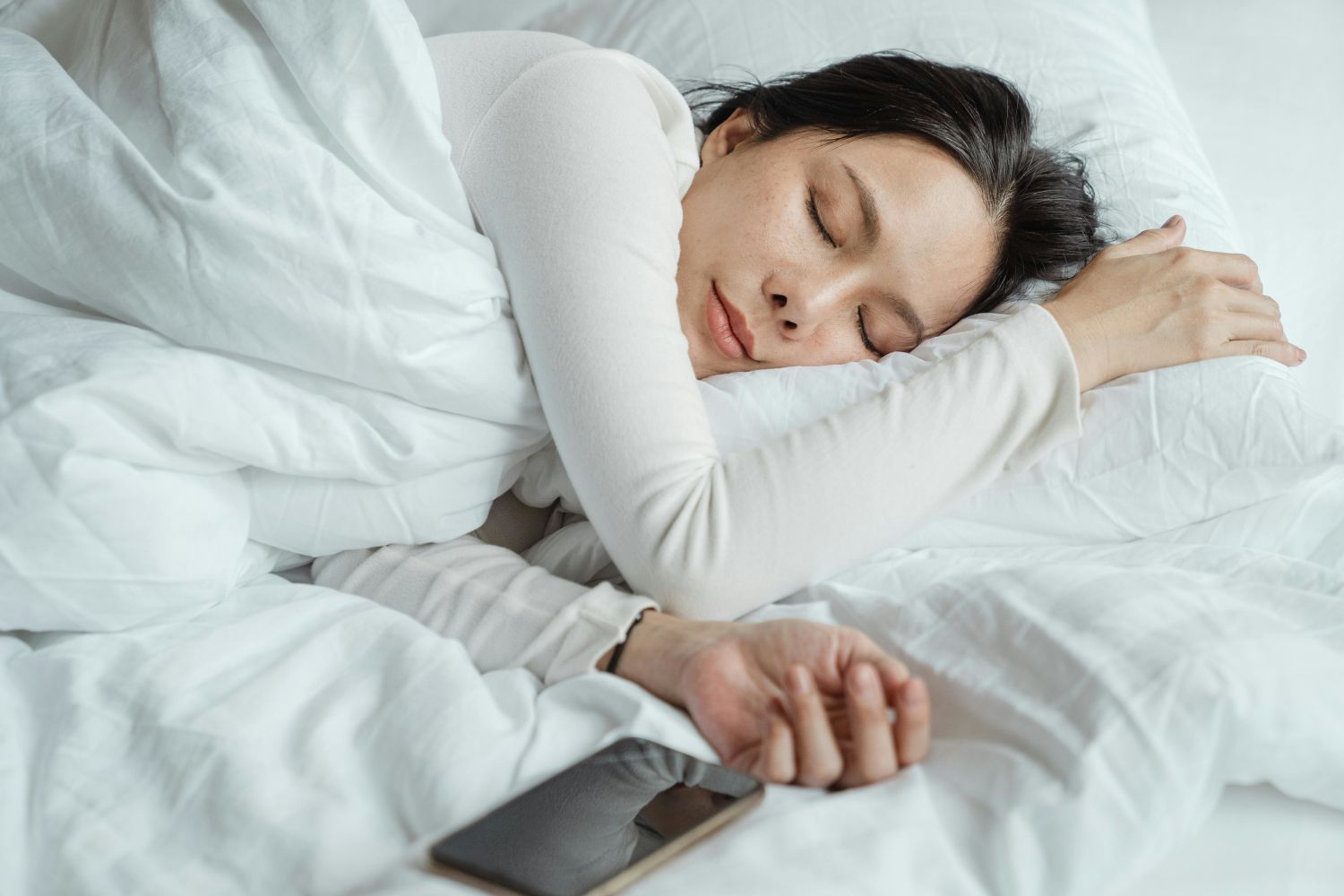 Woman sleeping with phone by her side