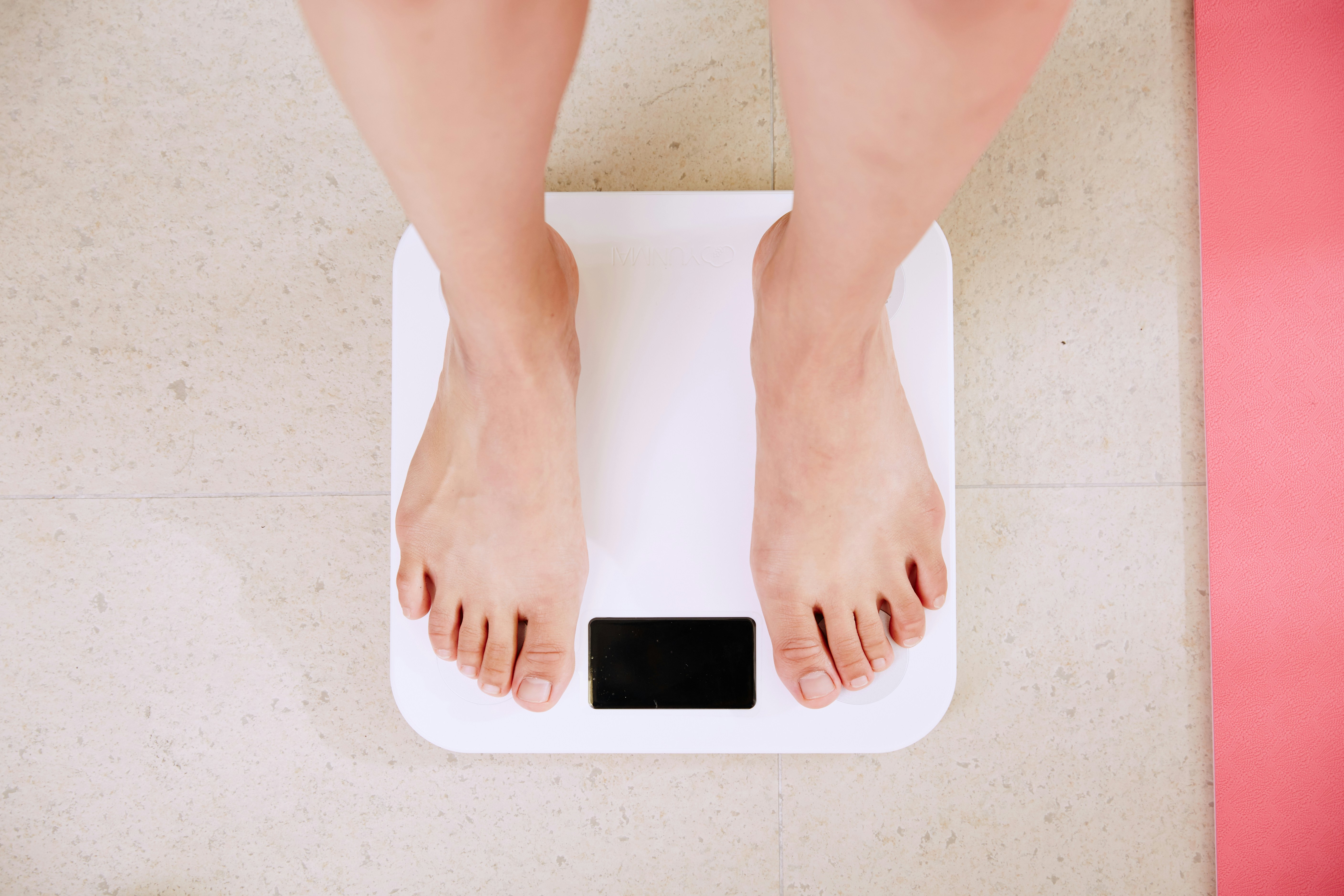 A person weighing themselves on scales.