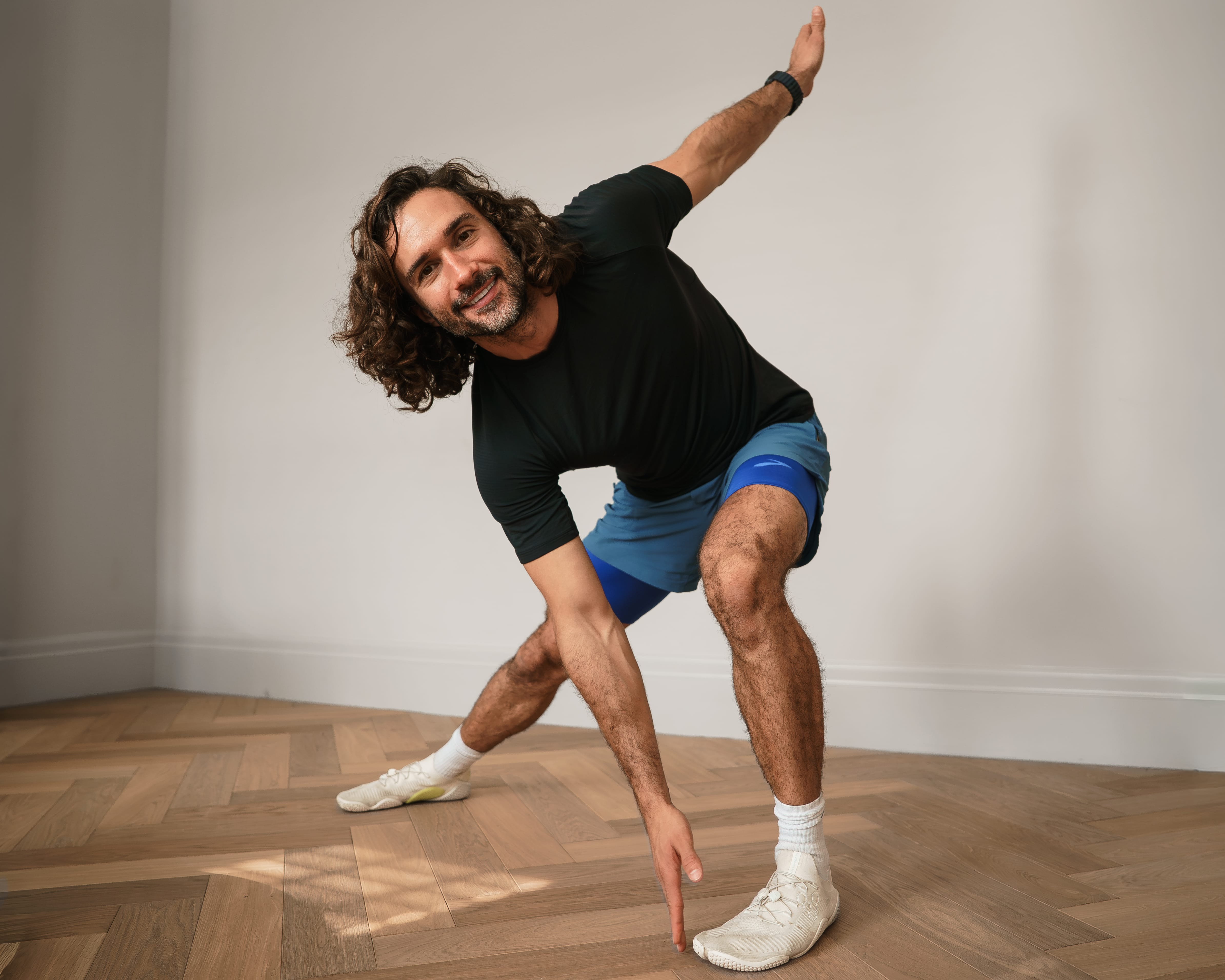 Joe Wicks performing a standing toe-touch