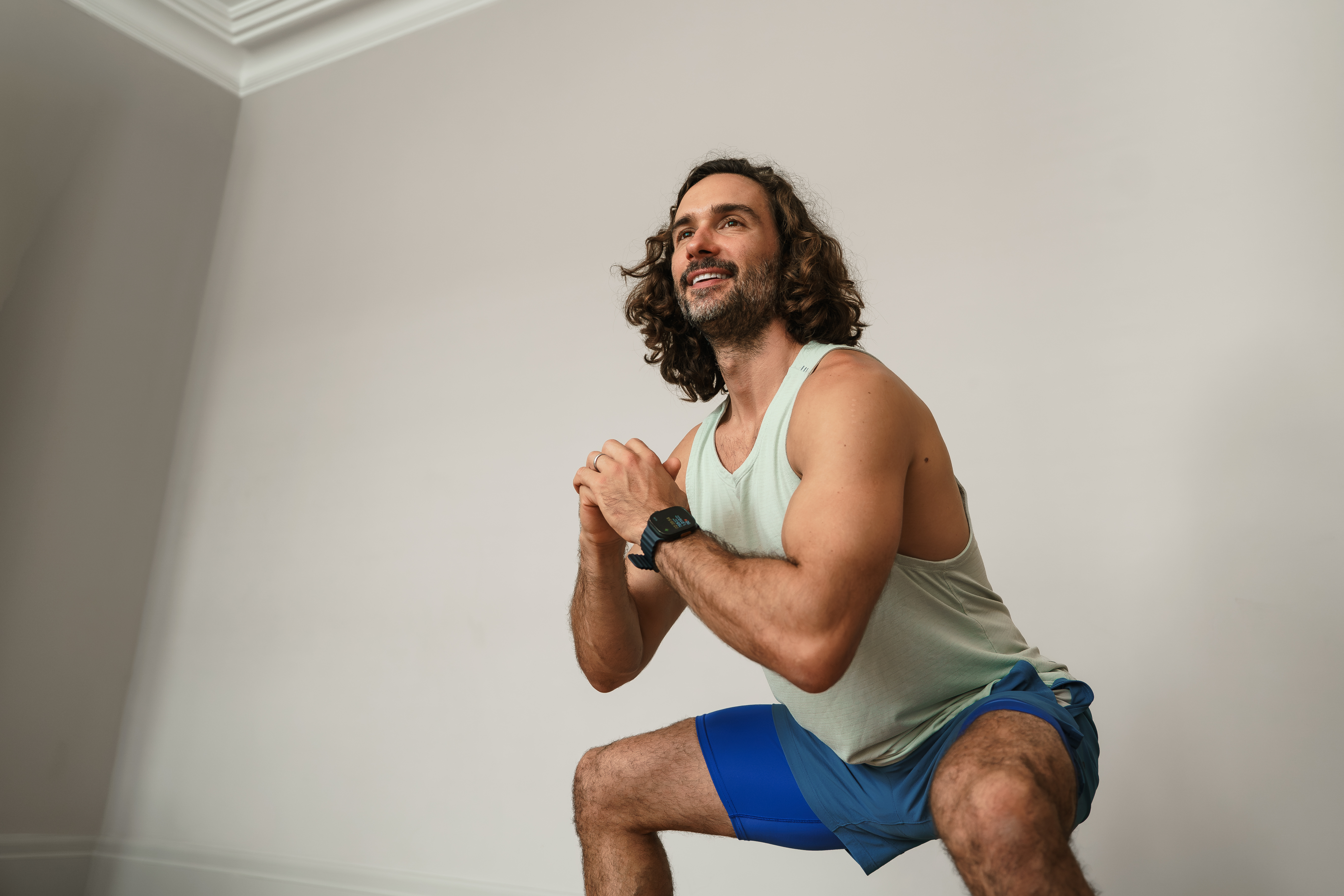 Joe wicks exercising doing a squat
