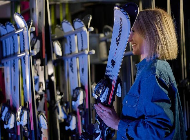 MIETSKI Mitarbeiterin Denise holt einen Kinderski aus dem Skiträger.