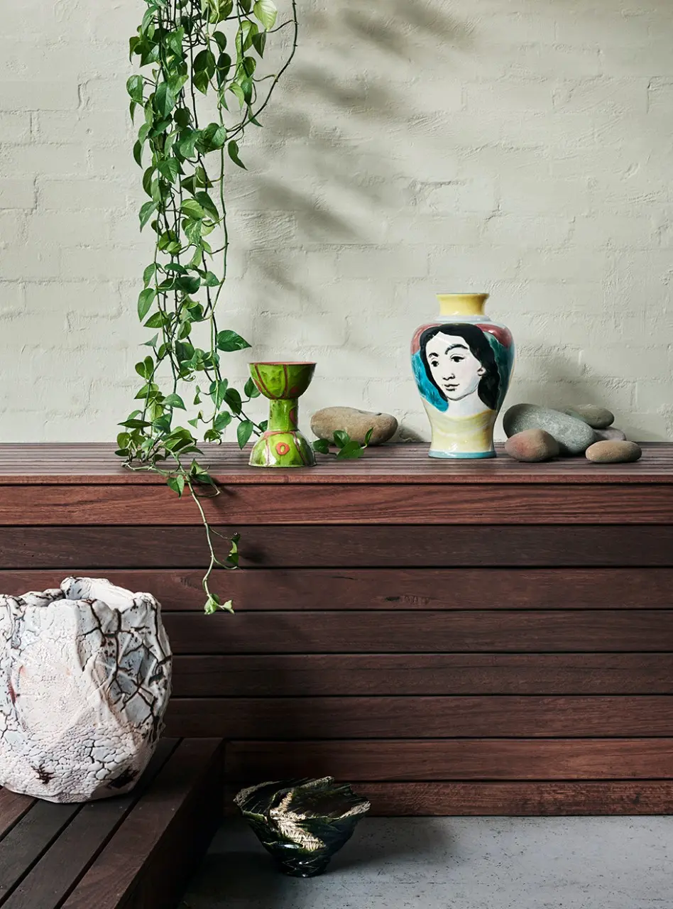 interior decor wooden bench seat with vase and plants.