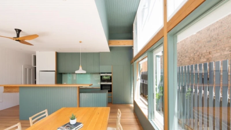 Green and white kitchen with timber trim