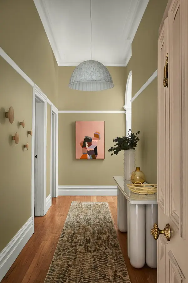 interior green hallway with pink accents and painting.