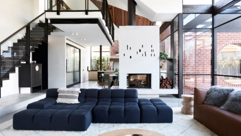 White high ceiling living room with navy sectional couch