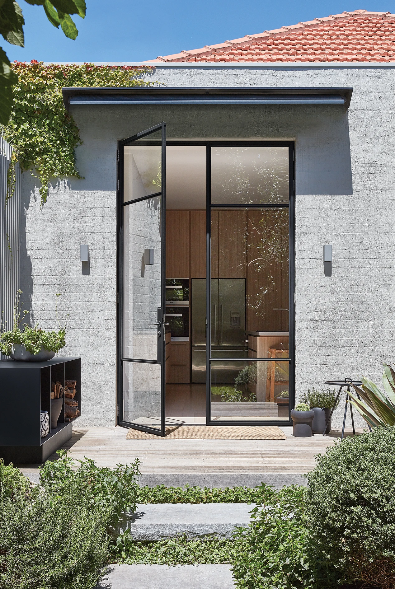 Grey house with black iron and glass doors