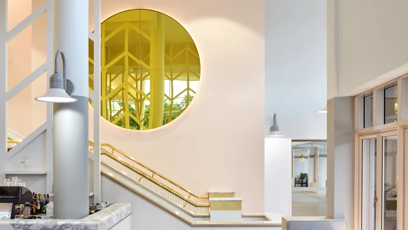 Reception area in peach and grey with circular yellow mirror