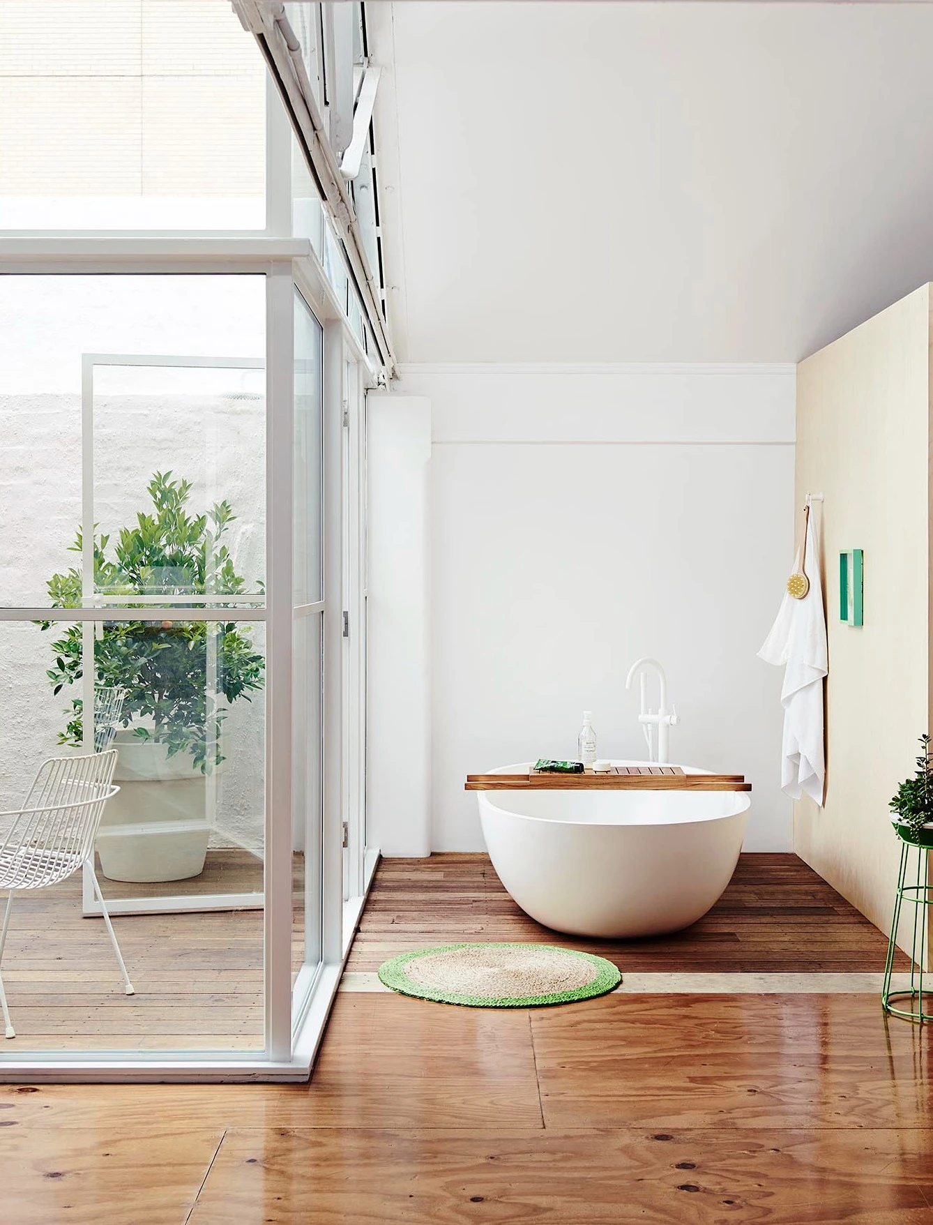 White walls bathroom with bathtub on a wooden floor