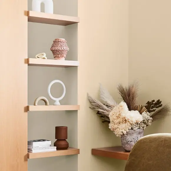 Built-in see-through wooden bookshelf containing decor in beige room