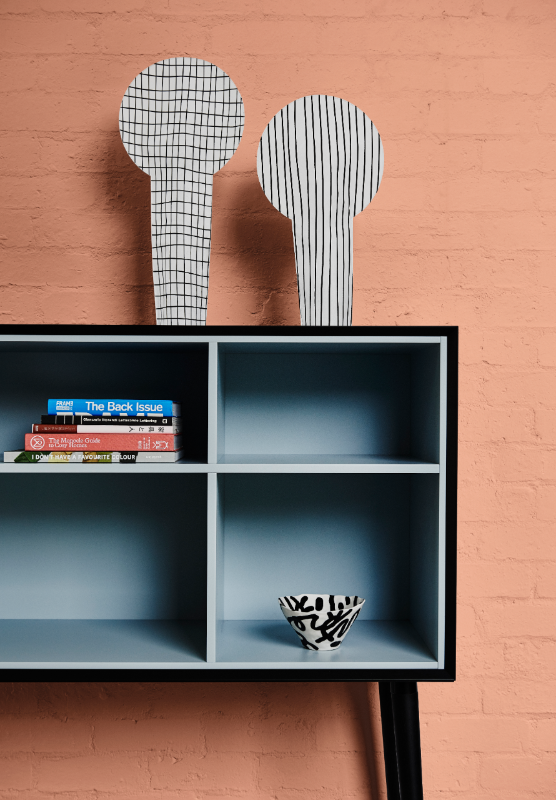 Black buffet with blue interior against a wall painted in Dulux Baby Melon.