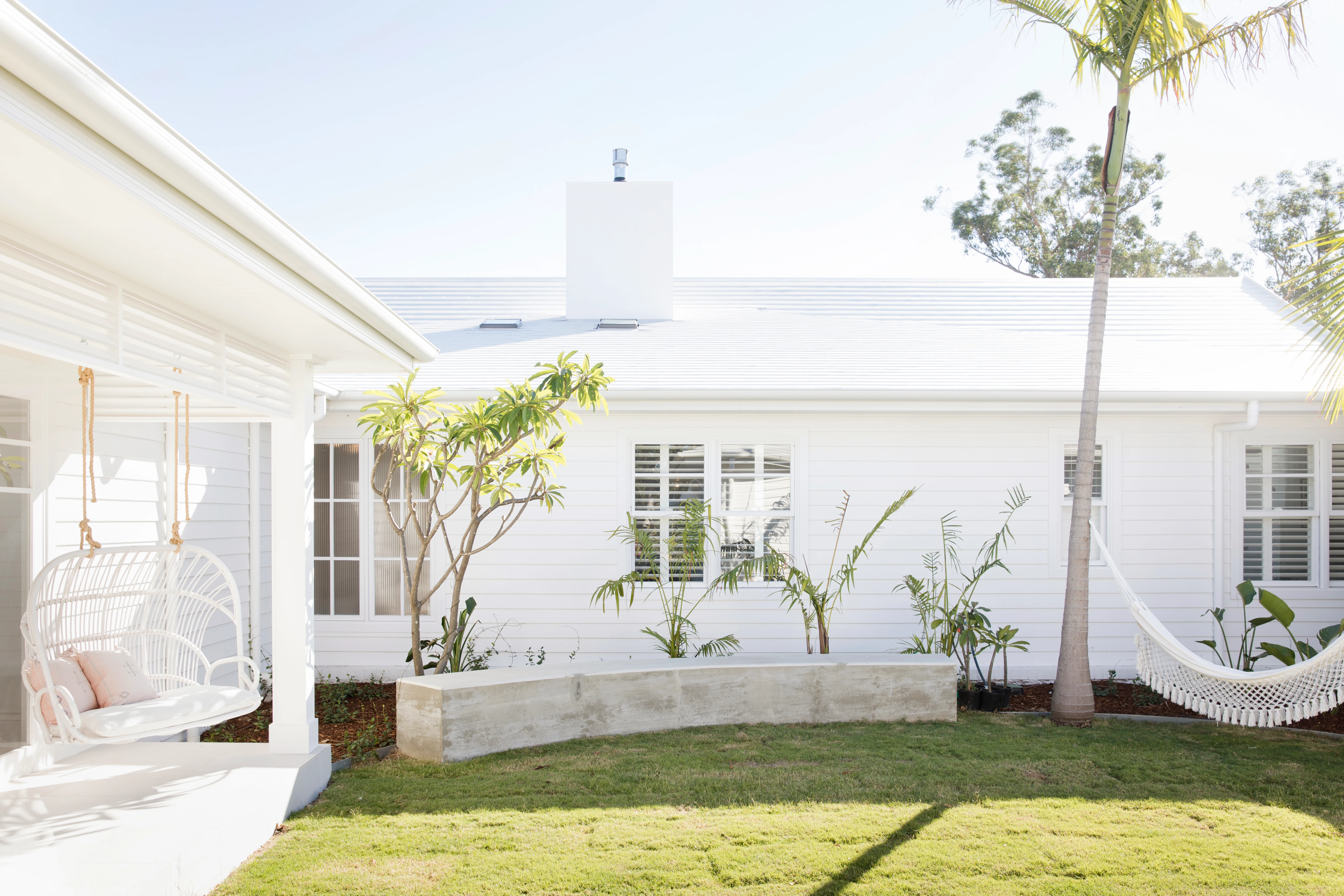 exterior, palm trees garden, hanging can chairs, hammock, white coastal house, Bonnie's Dream Home by Three Birds Renovations