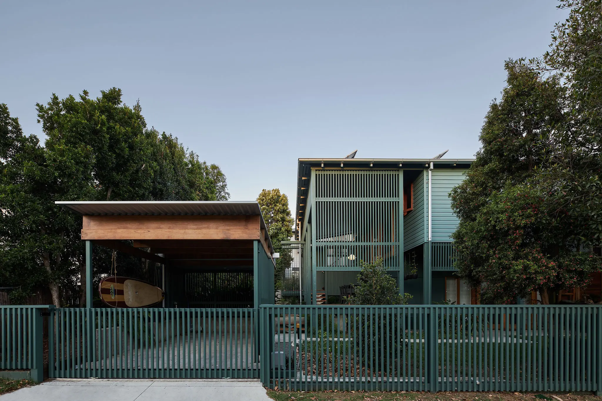 Green weatherboard house and carport