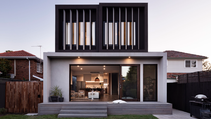 exterior two levelled house with large windows and panelling/privacy.