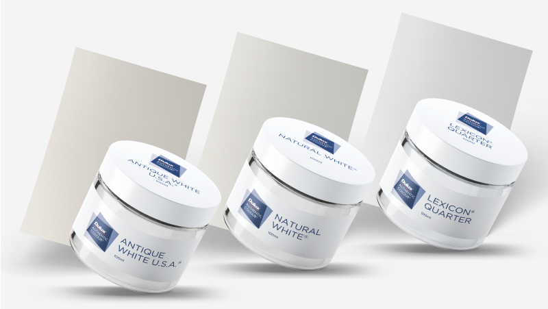 Three sample paint pots from the Dulux whites range in the colours Antique White U.S.A.®, Natural White™ and Lexicon® Quarter. 