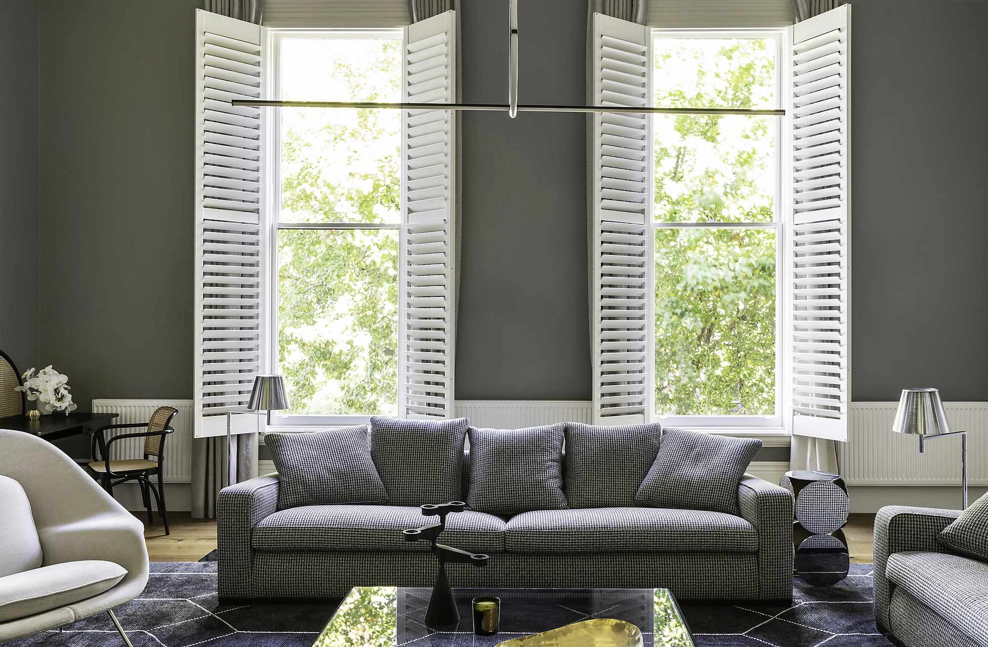 Grey living room with white plantation shutters.