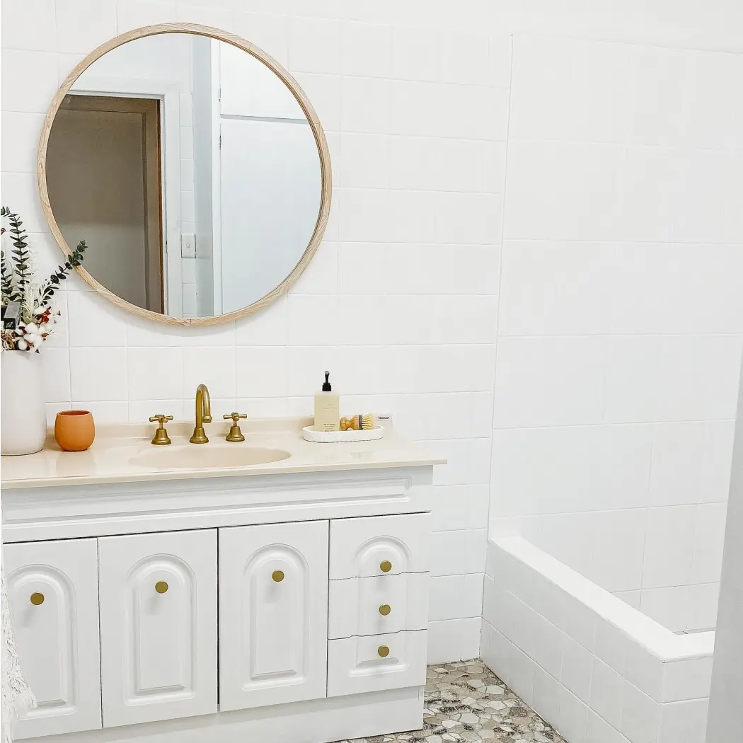 White bathroom and vanity with round mirror 