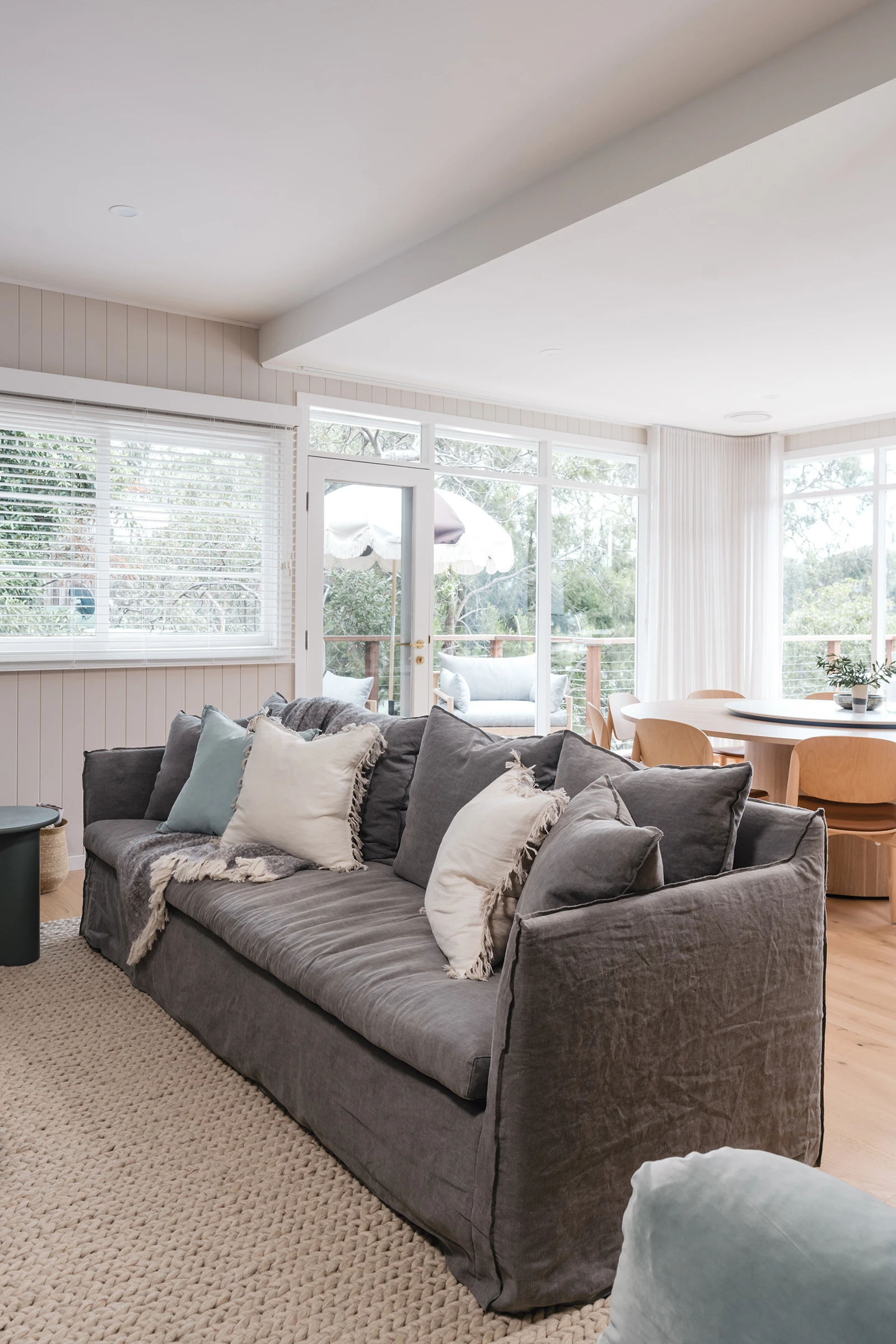 A comfortable grey sofa with cushions in a neutral living room