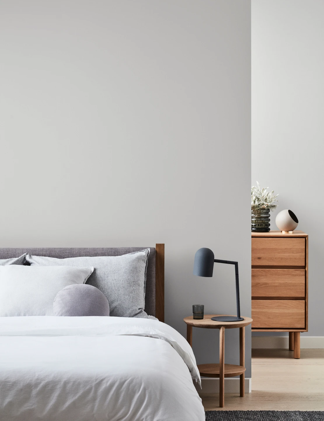 Bedroom with tranquil retreat coloured walls, grey styling and timber furnishings