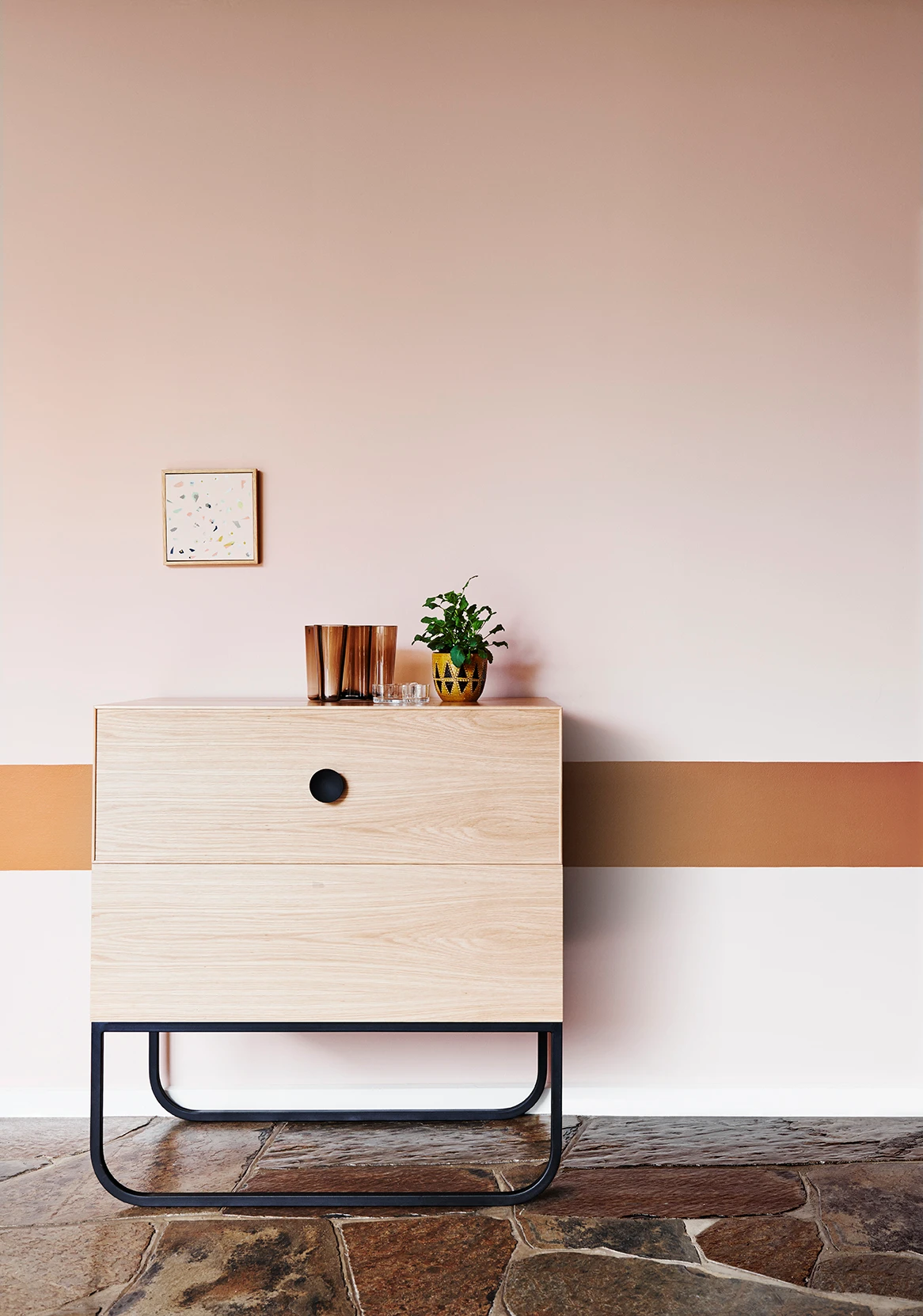 Pink wall with brown horizontal stripe and drawers