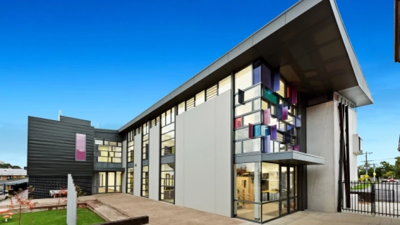 Grey modern school building with coloured glass