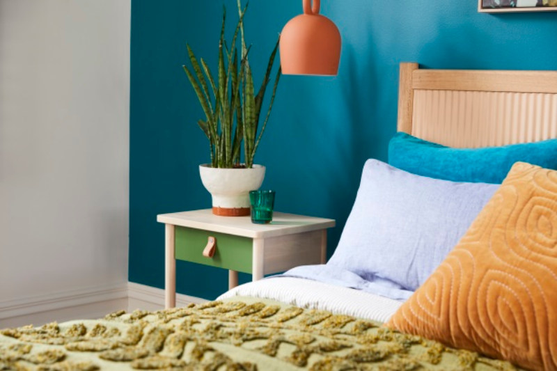 A side table in a blue-walled bedroom