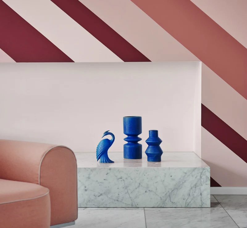 interior two toned pink wall with blue sculptures. 