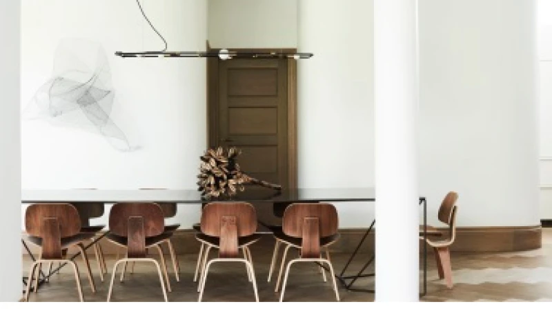 White dining rom with glass table and 10 wooden chairs