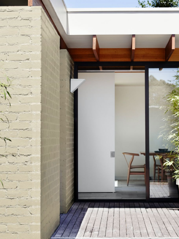 Exterior beige wall and wooden deck with view to dining. 