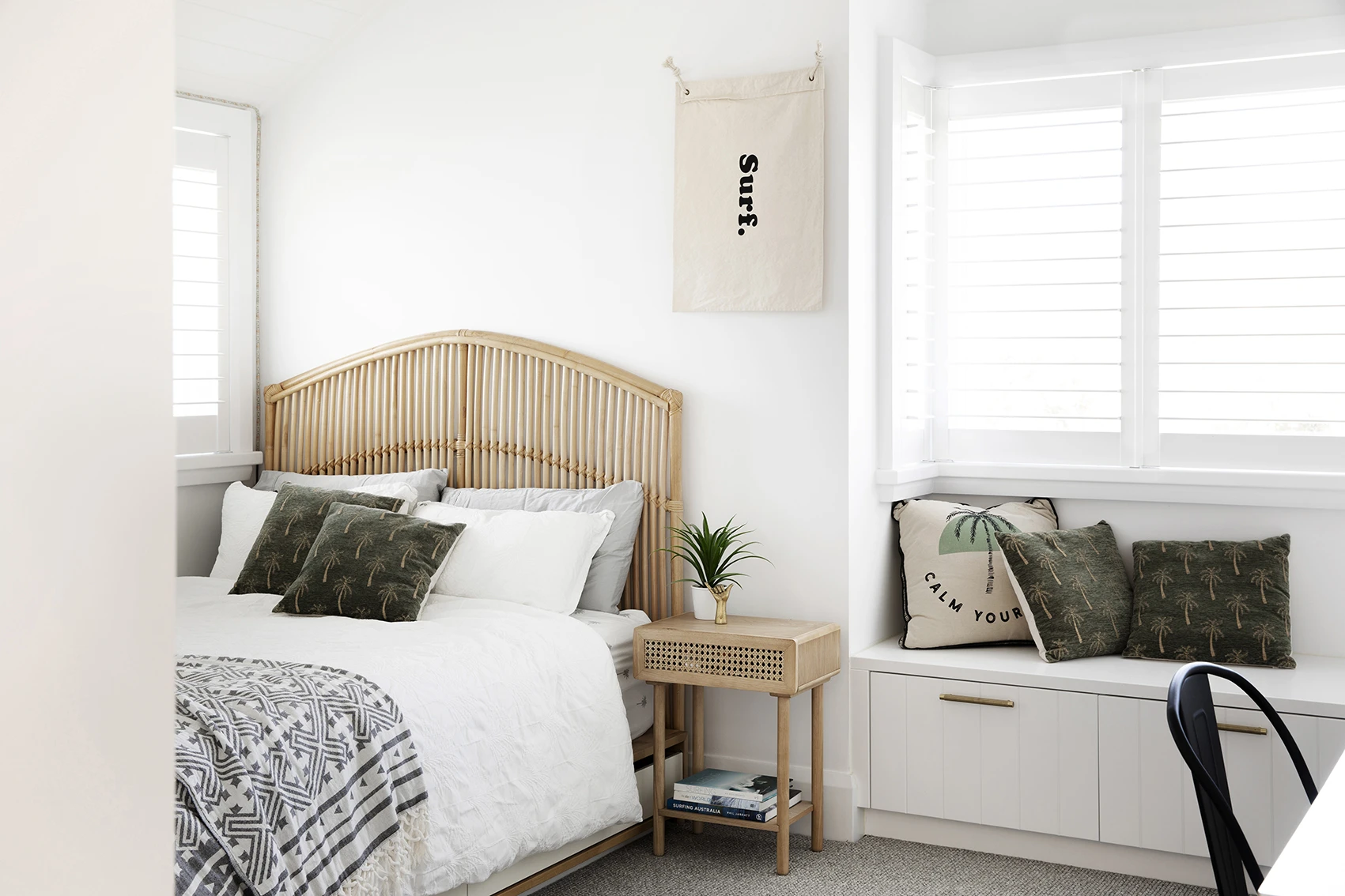 White bedroom with rattan headboard and side table