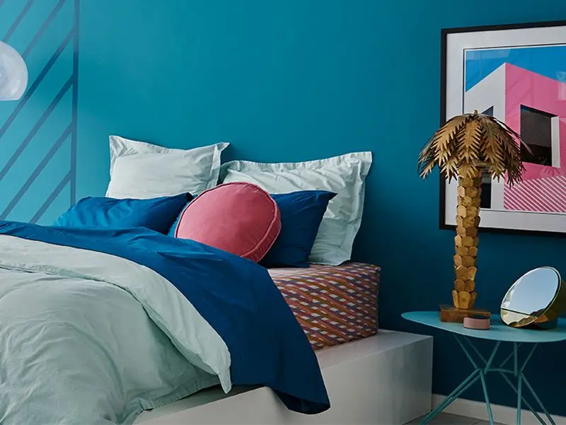 A blue bed in a blue-walled room