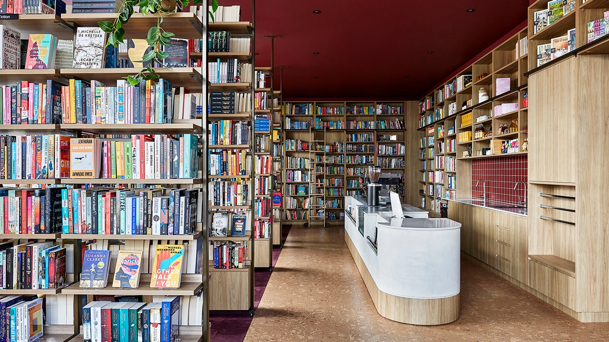 Bookshop with bookshelves full of books and customer service desk. 