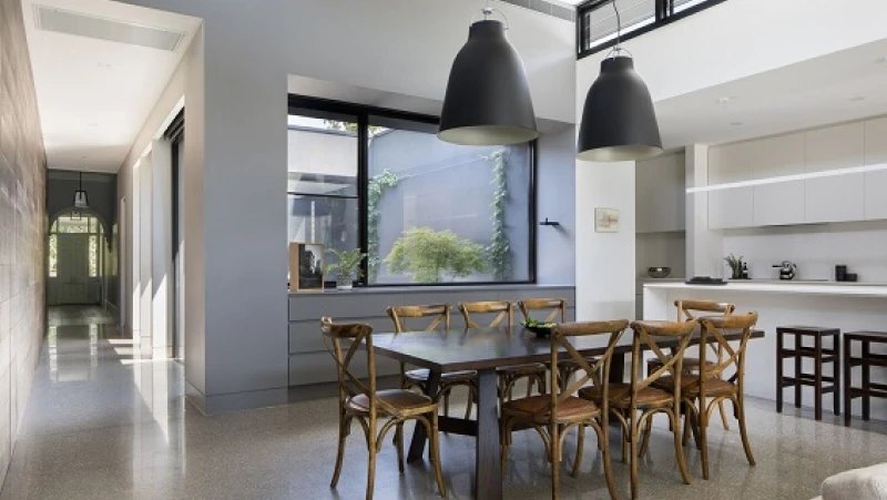 Grrey and white kitchen with two large black pendant lights over dining table