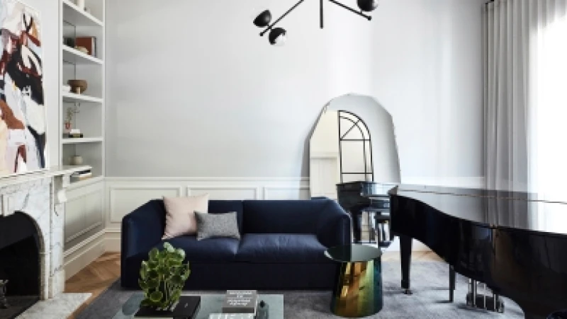 White living room with black grand piano and navy couch