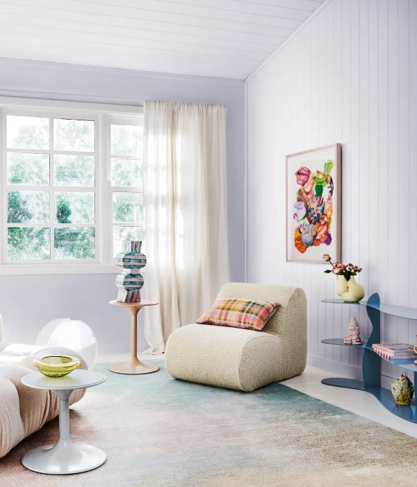 Living room with purple ceiling and walls, neutral armchair and blue low shelving.