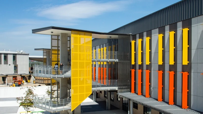 Double-storey building at Oran Park High School with orange and yellow screens 