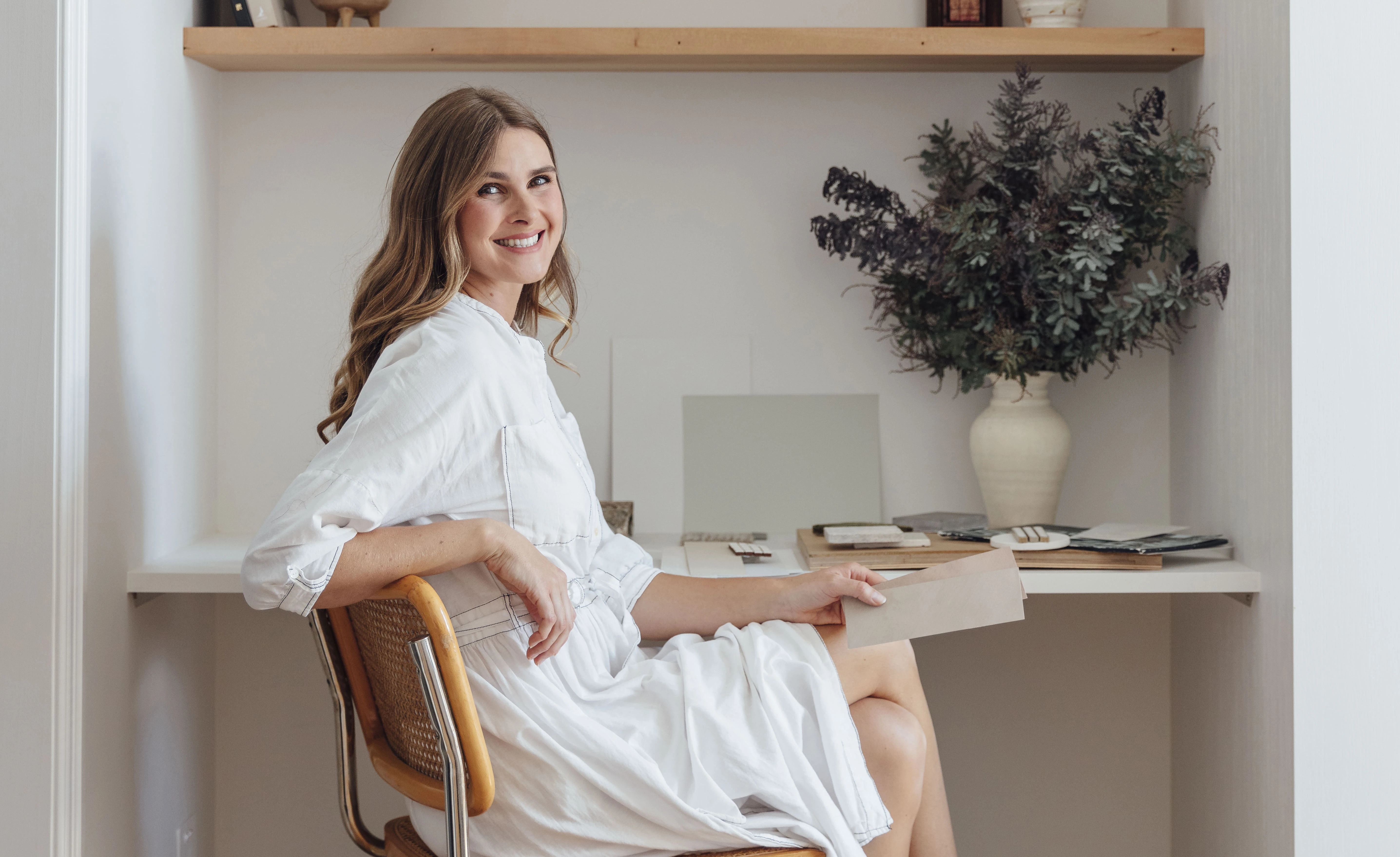 Jess Britten sitting at a desk looking and smiling at the camera.