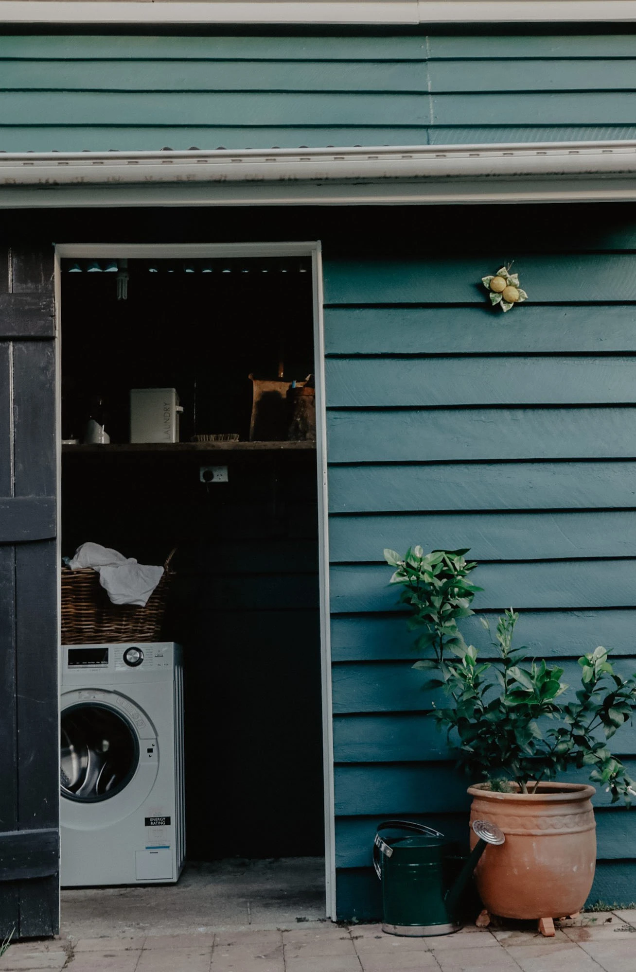 Dark green external laundry with black door