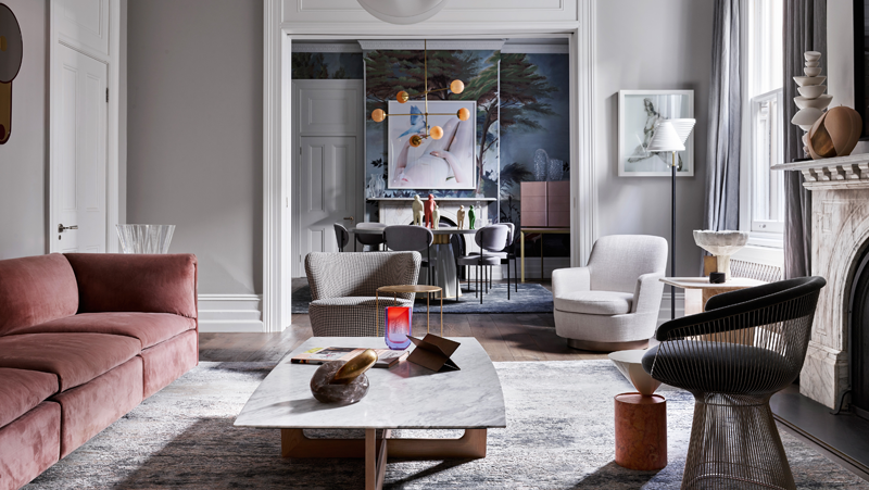 Grey living area with pink velvet couch leading through to formal dining room.