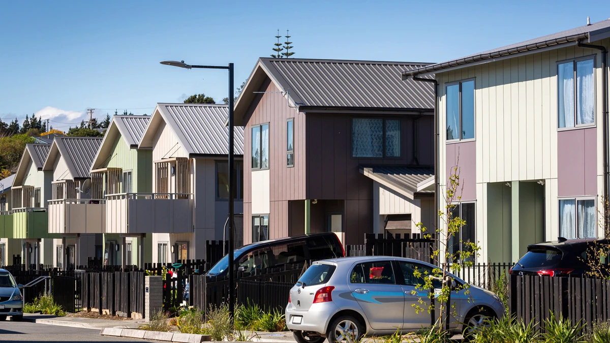 Row of houses with cars parked out the front.