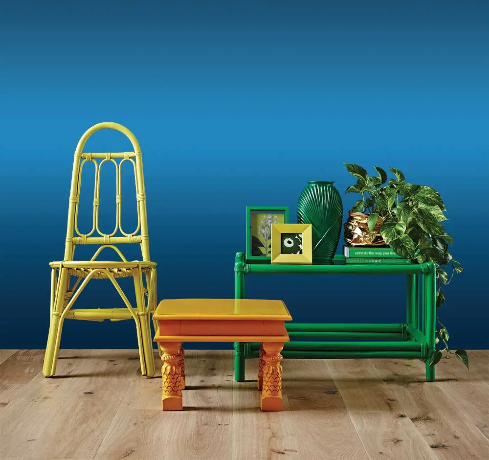 Yellow chair, orange side table and green coffee table with decor and plant
