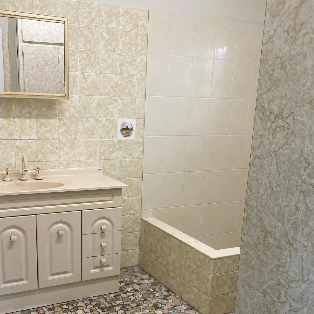 Outdated cream bathroom and vanity with brown floor tiles