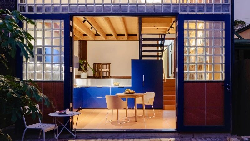 exterior view into blue dining area, with glass windows.