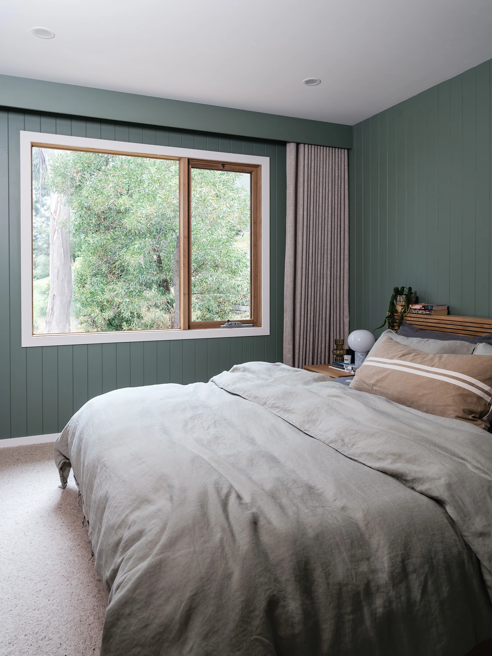 Guest bedroom with green walls and large window