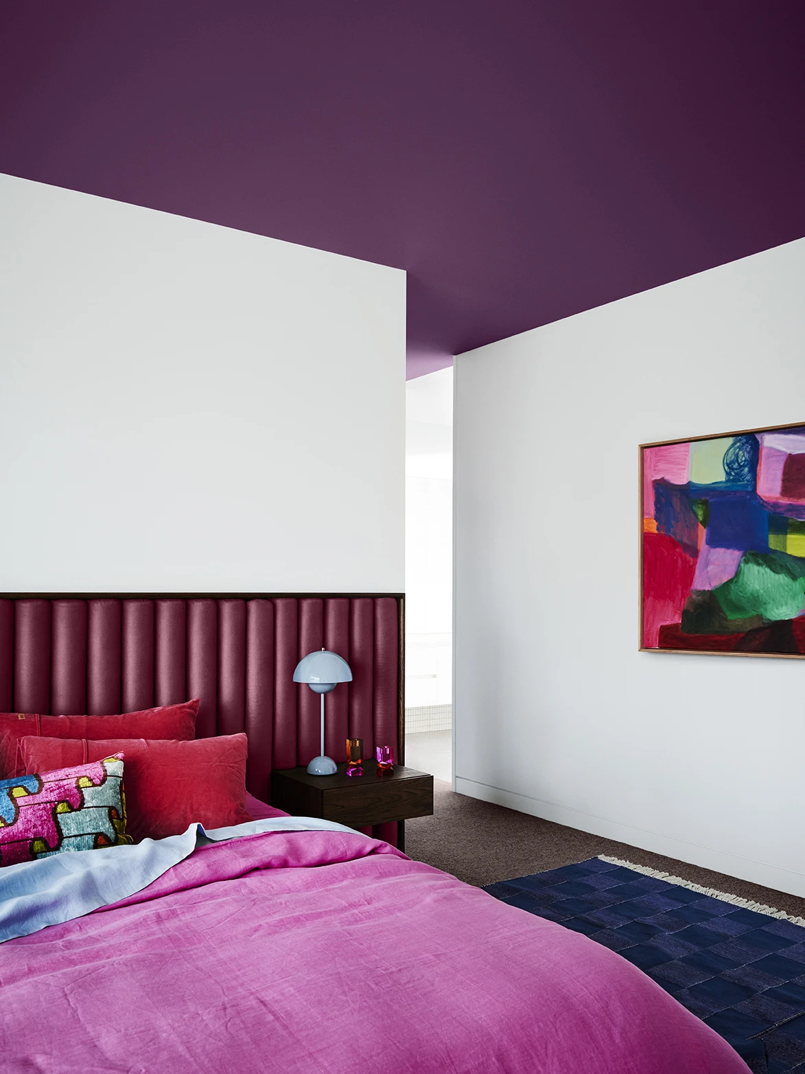 White bedroom with deep purple ceiling.