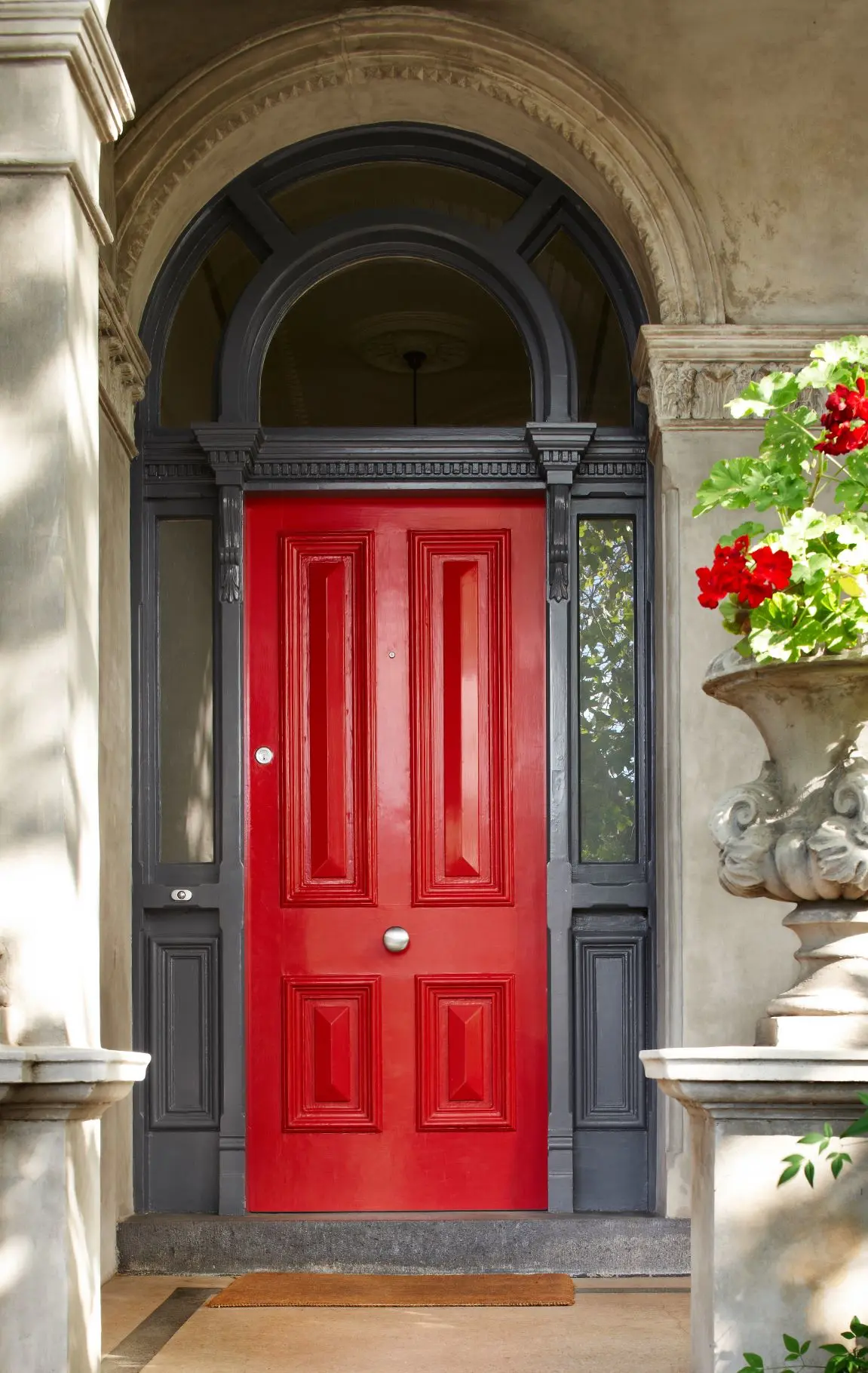 Narrow view of bright red door on traditional style home. 