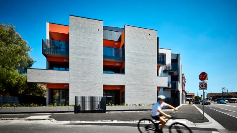 Concrete multi-storey apartment with orange trim.