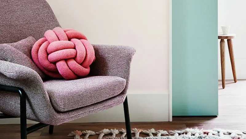 View of purple armchair with a pink pillow 